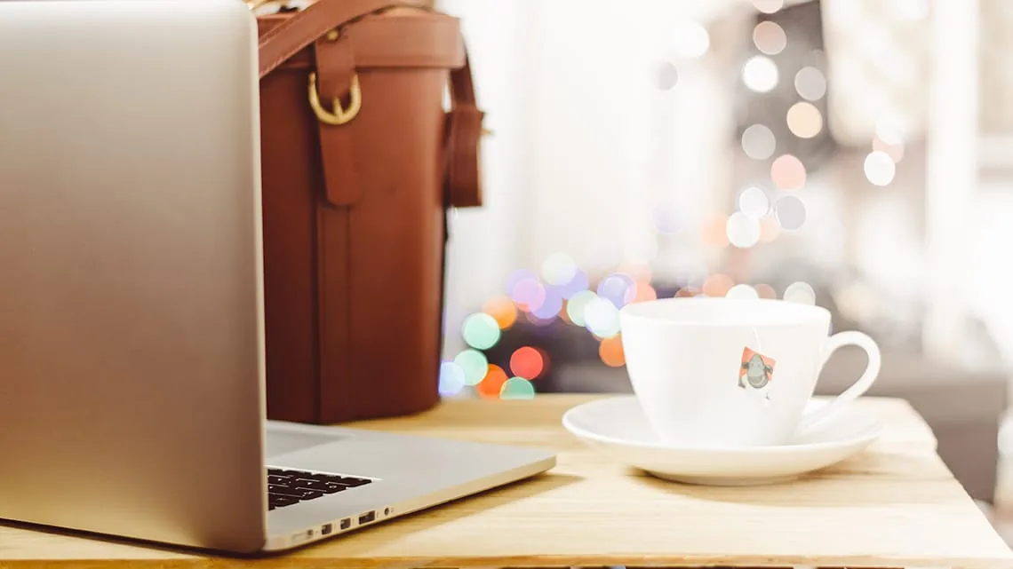 Otwarty MacBook i skórzana torba na drewnianym stole — Dlaczego nie bierzemy MacBook Air 11 cali (2015) do naprawy