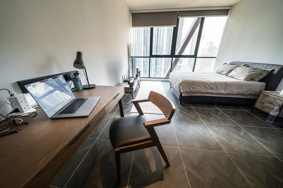 MacBook na biurku w nowoczesnym apartamentowym pokoju z łóżkiem w tle — Dlaczego nie bierzemy MacBook Pro 13 cali (2012) do naprawy