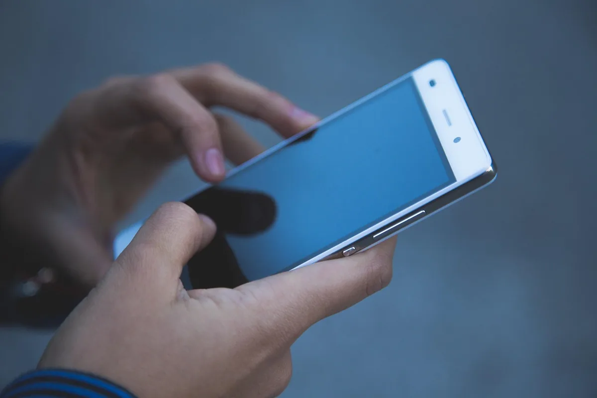 dłonie korzystające z nowoczesnego smartfona dotykowego — Dlaczego nie bierzemy OnePlus 9 do naprawy