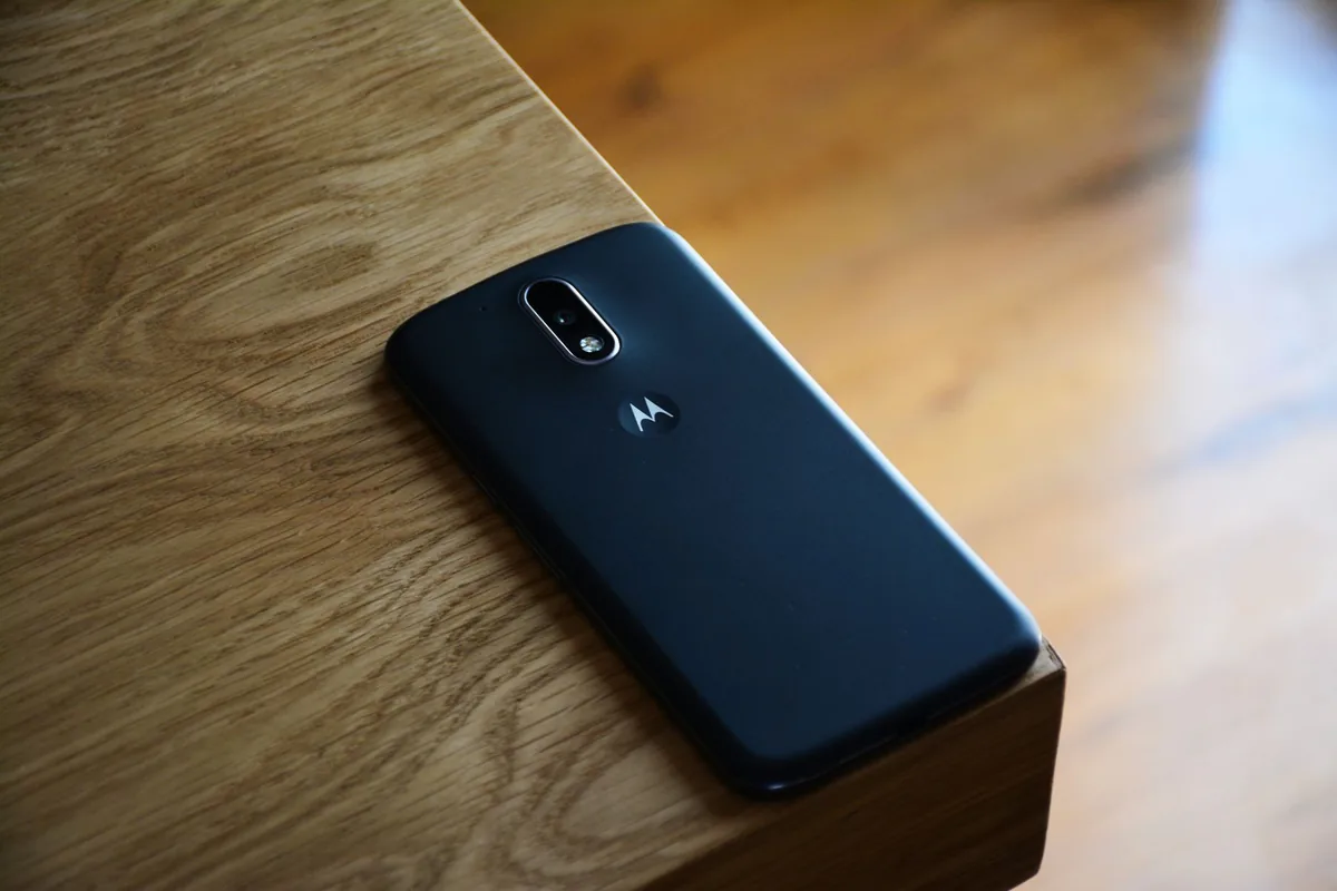 czarny smartfon na drewnianym biurku w naturalnym świetle — Dlaczego nie bierzemy OPPO A58 do naprawy