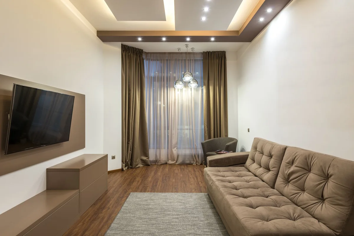 telewizor z płaskim ekranem i sofa w beżowym salonie — Dlaczego nie bierzemy Philips OLED908 do naprawy