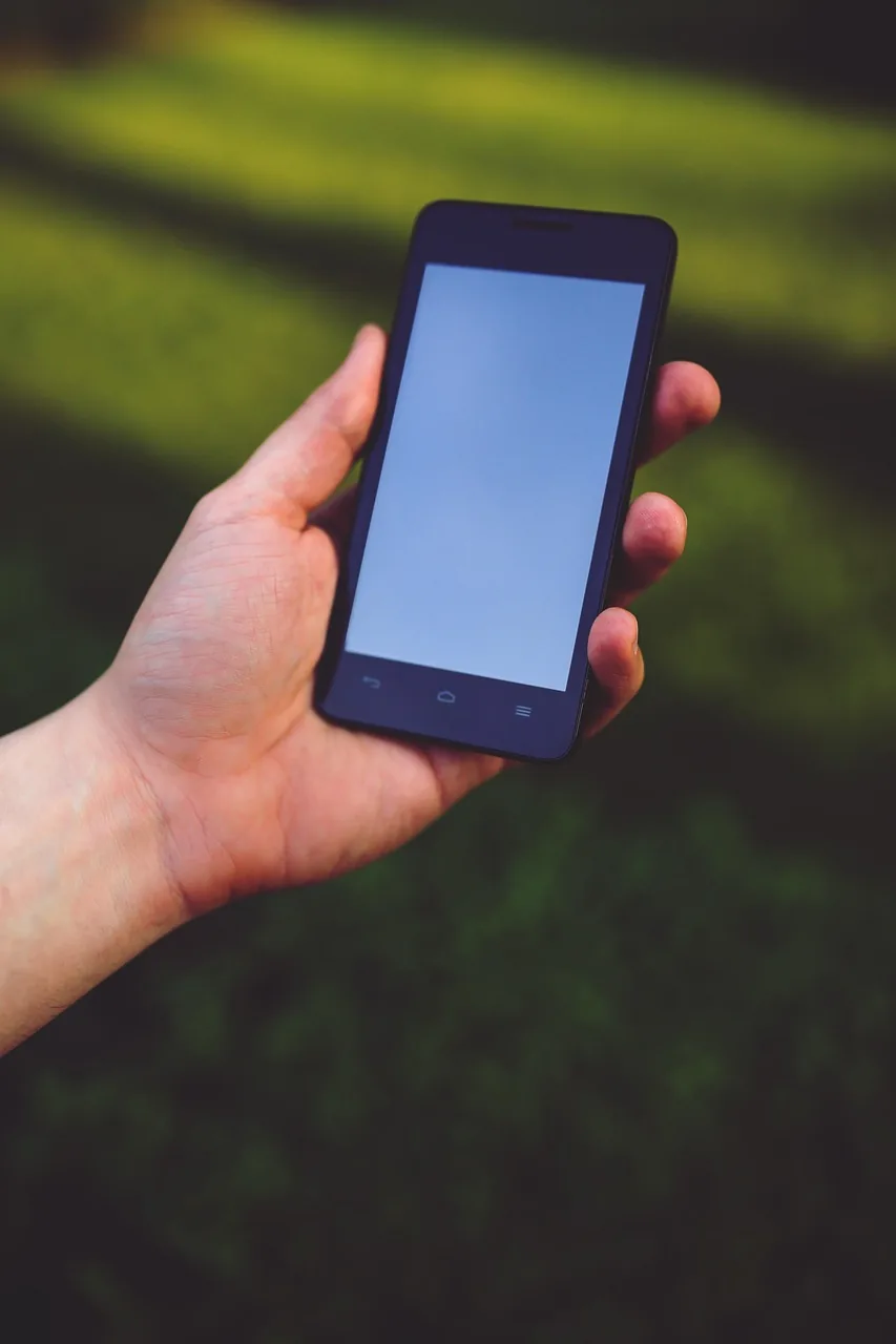 dłoń trzymająca nowoczesny dotykowy smartfon — Dlaczego nie bierzemy POCO M6 do naprawy