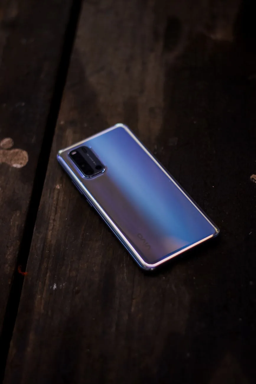 srebrny smartfon na rustykalnym drewnianym stole — Dlaczego nie bierzemy realme GT Neo 3 do naprawy