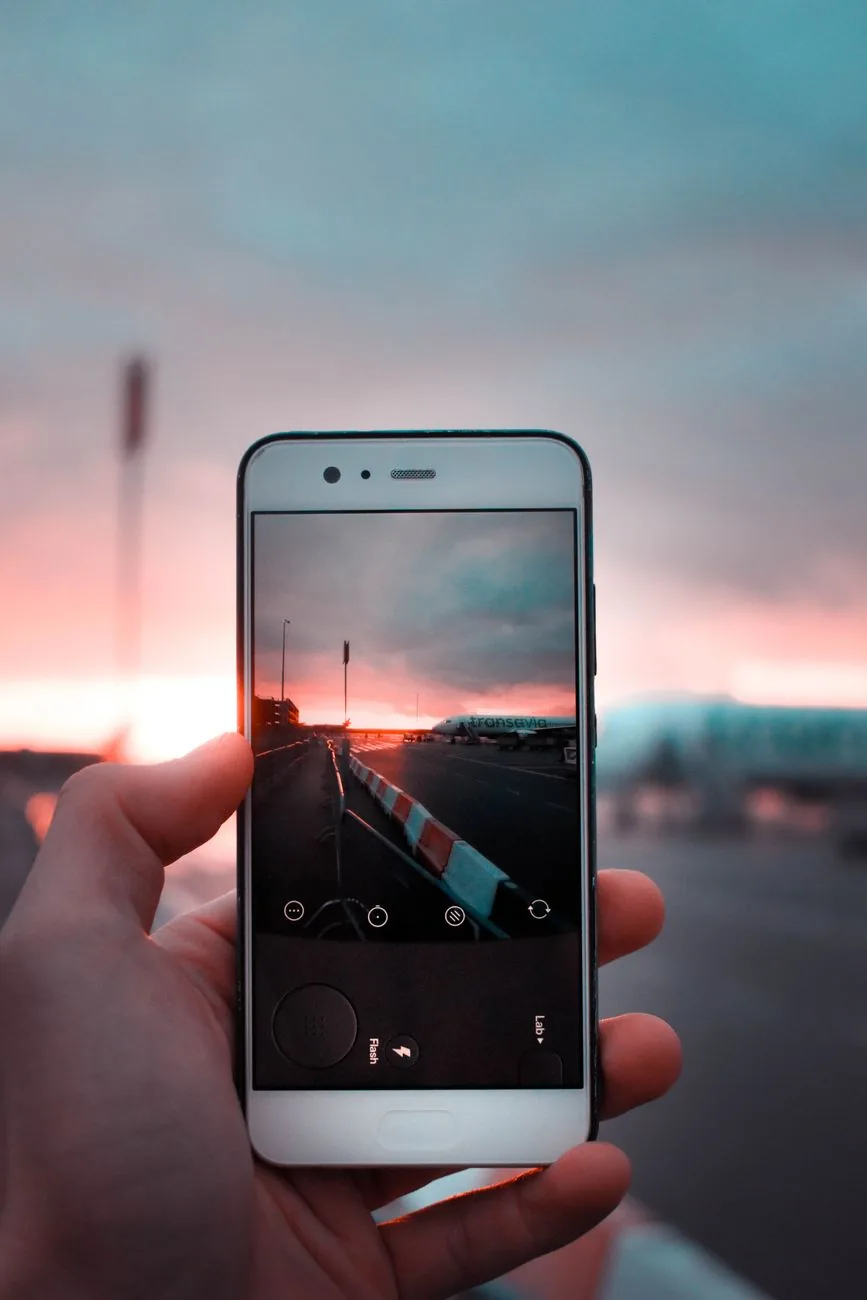 dłoń ze smartfonem na tle zachodu słońca — Dlaczego nie bierzemy Redmi 6 do naprawy
