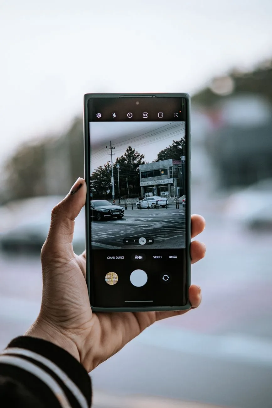 dłoń trzymająca smartfon na tle ulicy — Dlaczego nie bierzemy Samsung Galaxy A16 5G do naprawy