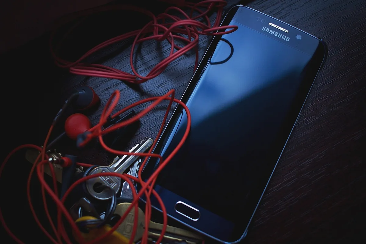 smartfon samsung, słuchawki i klucze na stole — Dlaczego nie bierzemy Samsung Galaxy A52s 5G do naprawy