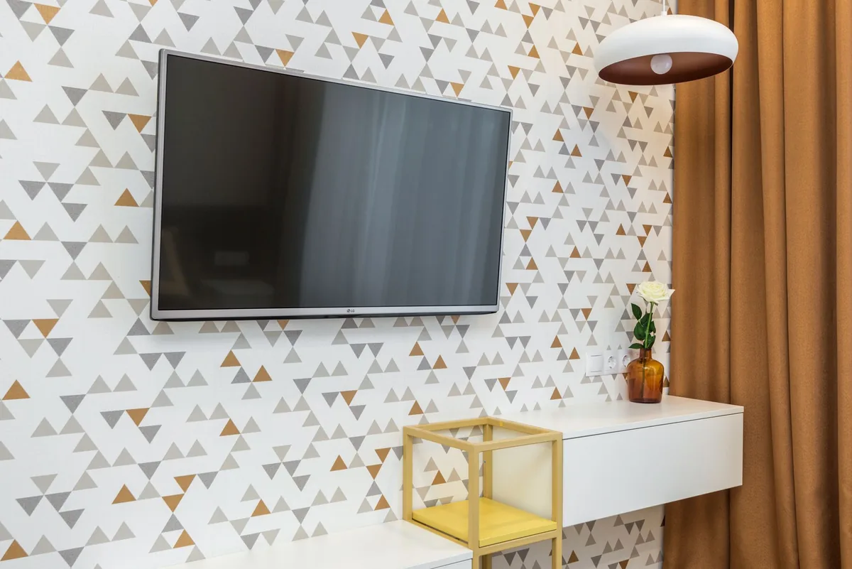 telewizor na ścianie w salonie z wazonem kwiatów — Dlaczego nie bierzemy Xiaomi TV Q2 do naprawy
