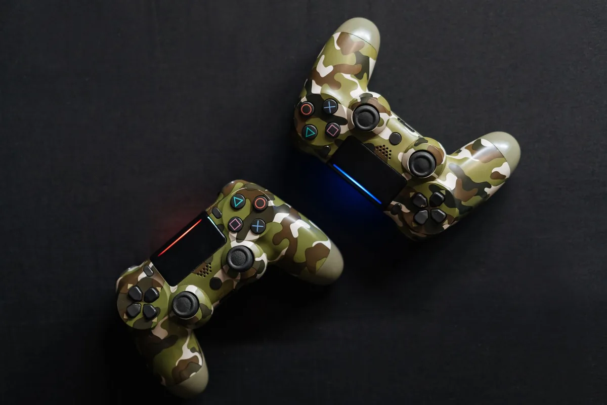 dwa kontrolery do gier w barwach moro — DualShock 4 poza naszym warsztatem — gdzie szukać pomocy