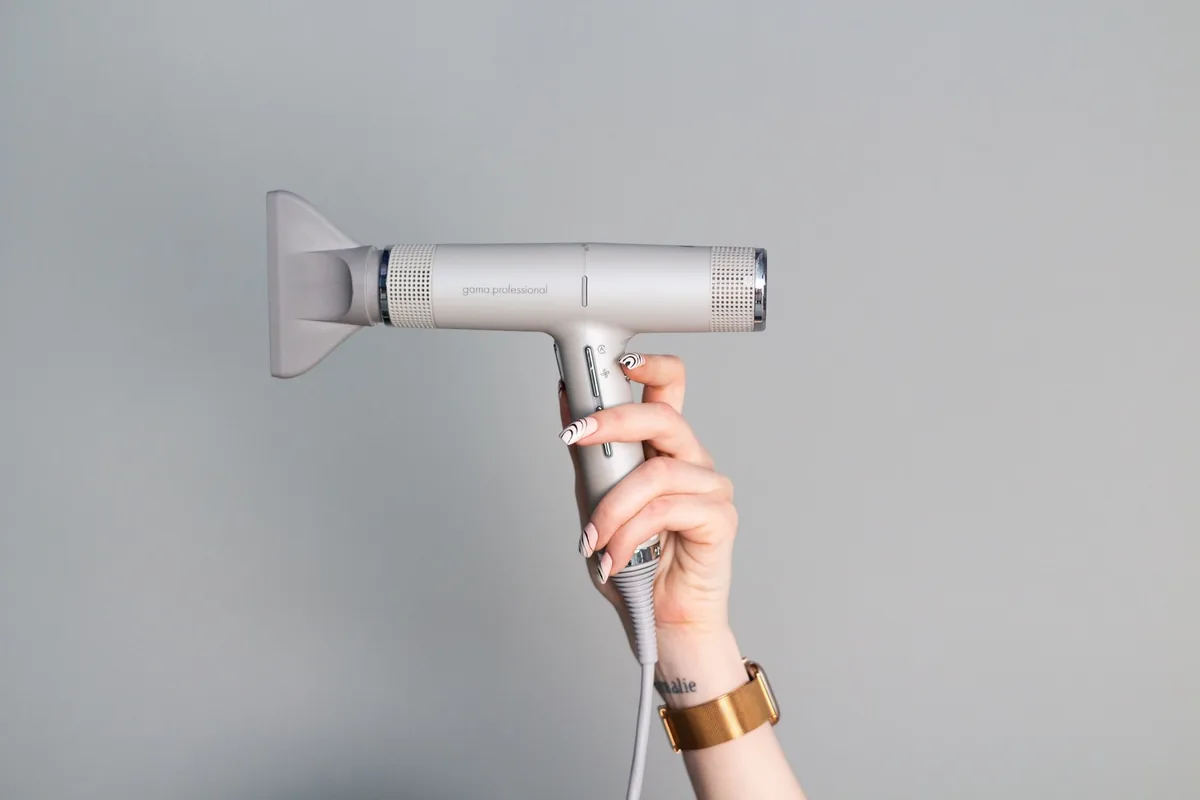 dłoń trzymająca nowoczesną suszarkę do włosów — Dyson Supersonic Nural w zgłoszeniu — jak odpowiadamy i co radzimy