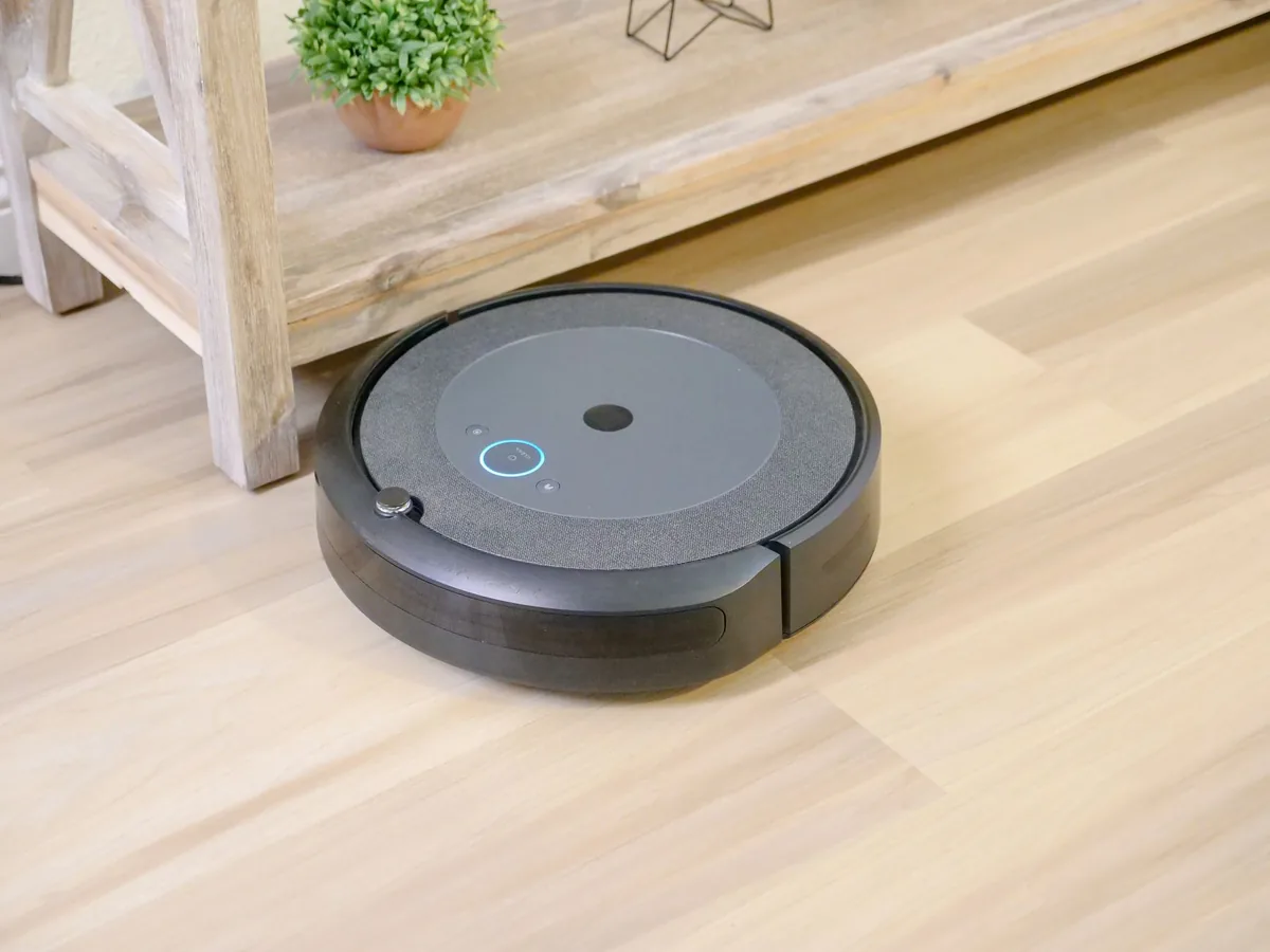 robot sprzątający na podłodze obok rośliny doniczkowej — Ecovacs Deebot N8 a zakres naszego serwisu — czym zajmujemy się zamiast