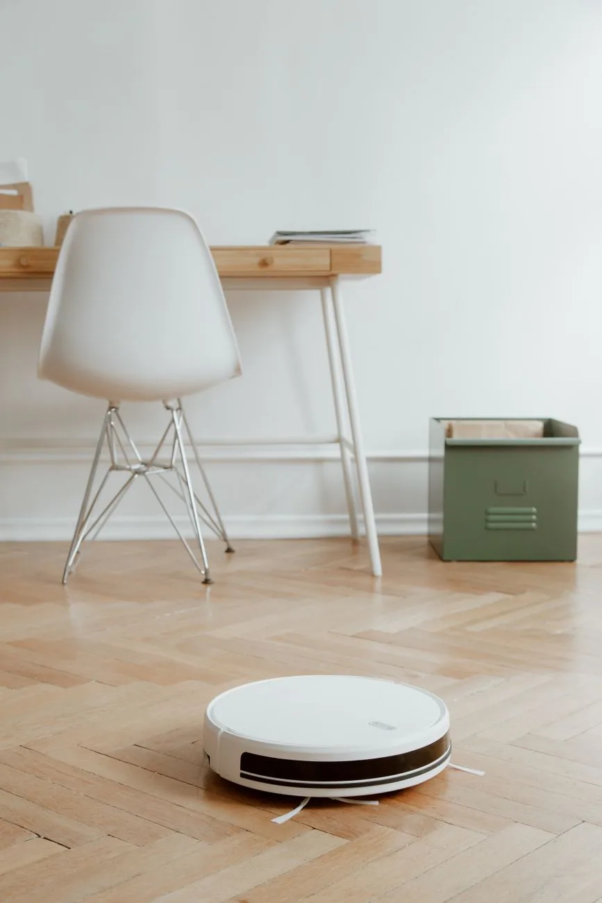 robot sprzątający na drewnianej podłodze obok biurka — Ecovacs Deebot T20 Omni w zgłoszeniu — jak odpowiadamy i co radzimy