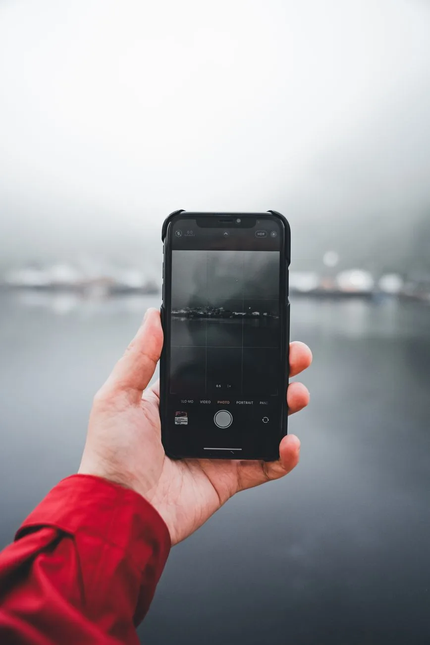 dłoń z telefonem rejestrująca zamglone jezioro — Fairphone 4 — czego przy tym sprzęcie nie zrobimy