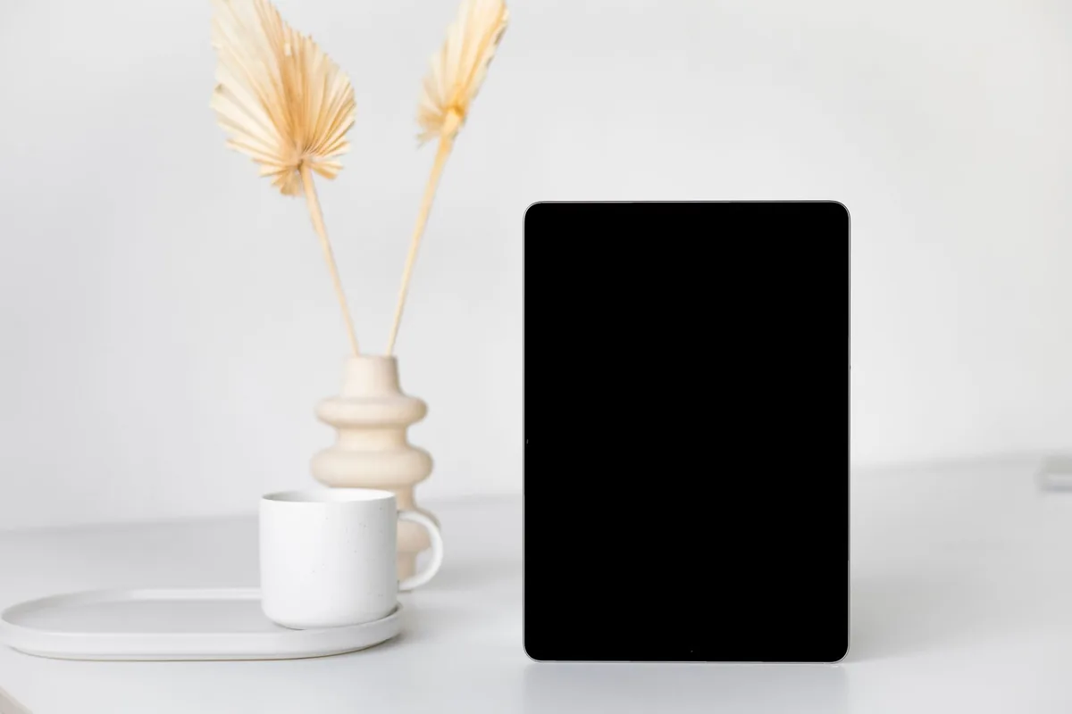 tablet, wazon z suszonymi liśćmi i kubek na biurku — Galaxy Tab S9 FE poza naszym warsztatem — gdzie szukać pomocy