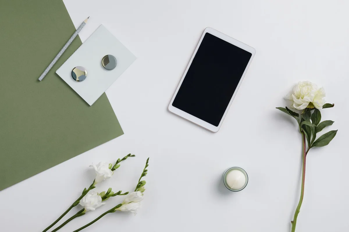 tablet w otoczeniu kwiatów i przyborów piśmienniczych na białym tle — Galaxy Tab S9 Ultra a zakres naszego serwisu — czym zajmujemy się zamiast