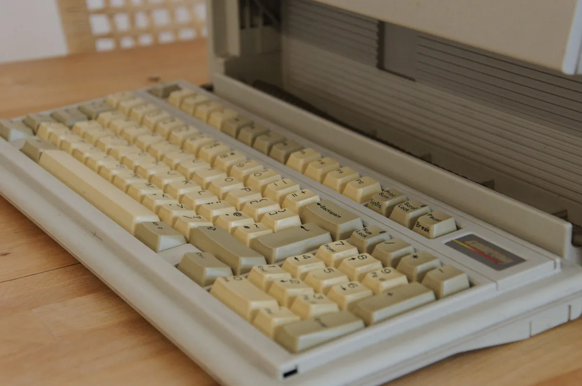 stara klawiatura z pożółkłymi klawiszami na drewnianym biurku — Genesis Rhod 300 — czego przy tym sprzęcie nie zrobimy