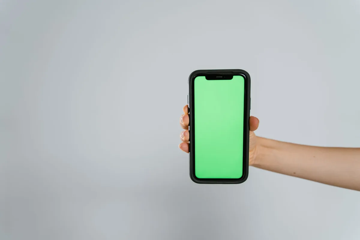 dłoń trzymająca telefon z zielonym ekranem — Google Pixel 4a a zakres naszego serwisu — czym zajmujemy się zamiast