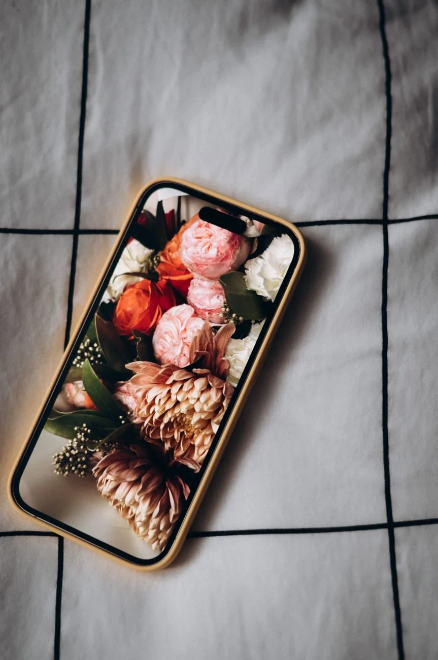 telefon komórkowy z motywem kwiatowym na ekranie leżący na łóżku — Google Pixel 9 Pro Fold poza naszym warsztatem — gdzie szukać pomocy