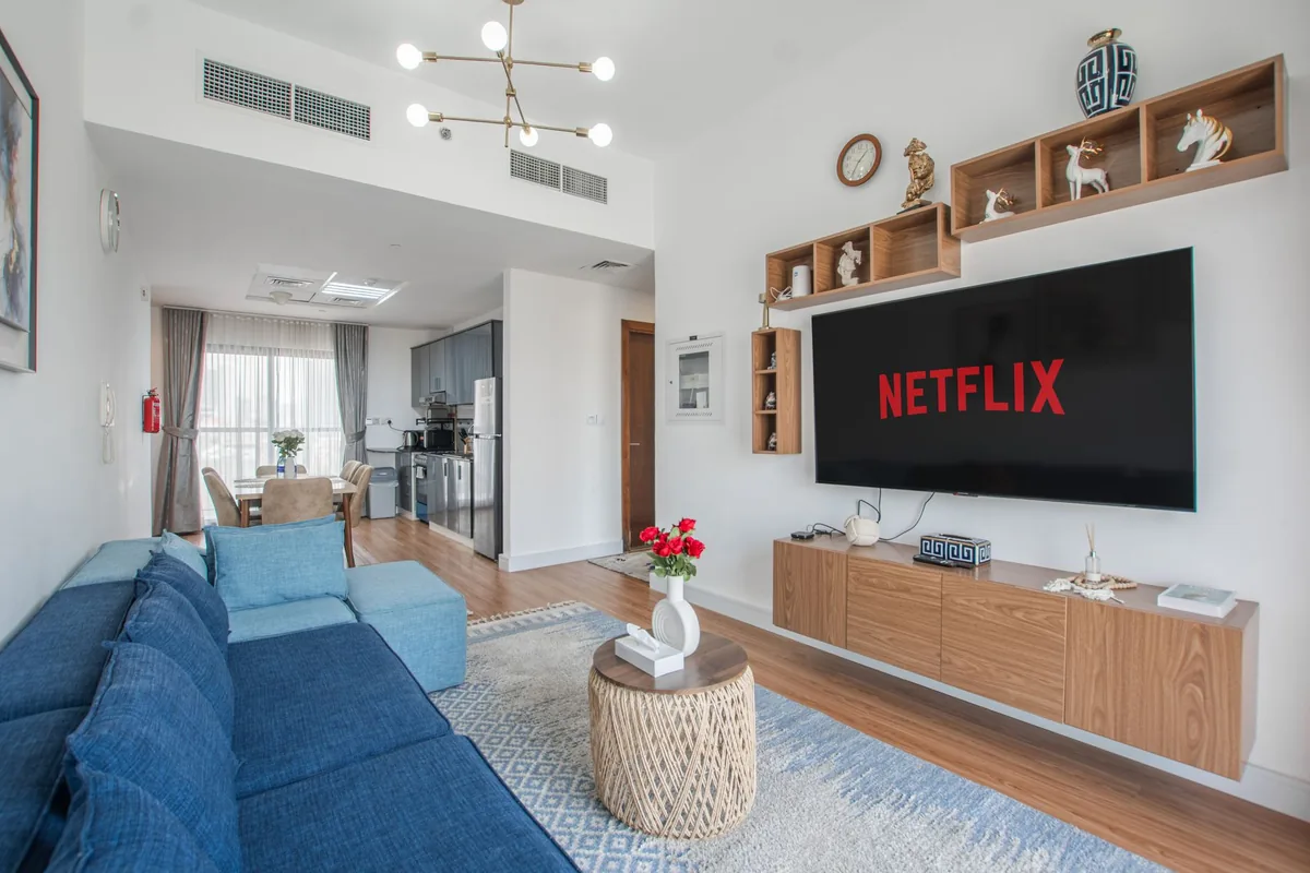 telewizor z aplikacją netflix nad niebieską sofą w salonie — Hisense A6N a zakres naszego serwisu — czym zajmujemy się zamiast