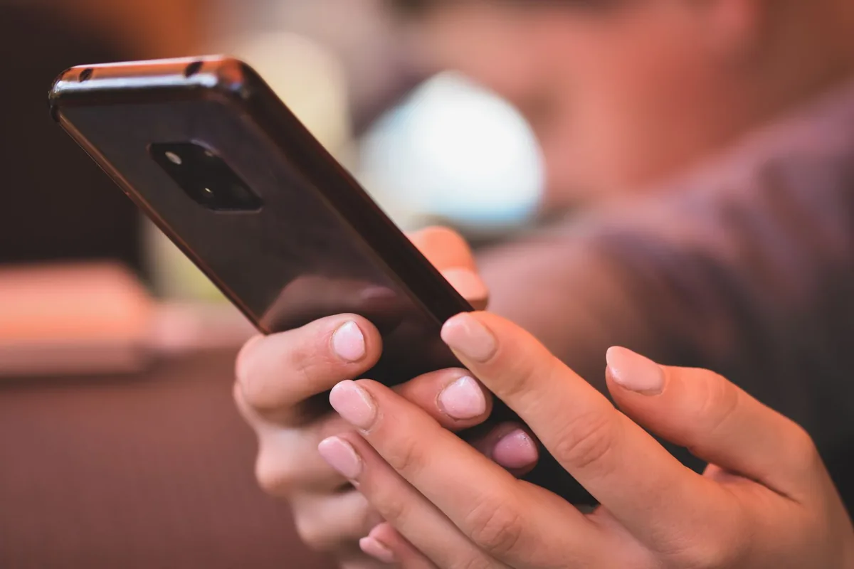 dłonie trzymające smartfon we wnętrzu pomieszczenia — Honor 50 Lite w zgłoszeniu — jak odpowiadamy i co radzimy