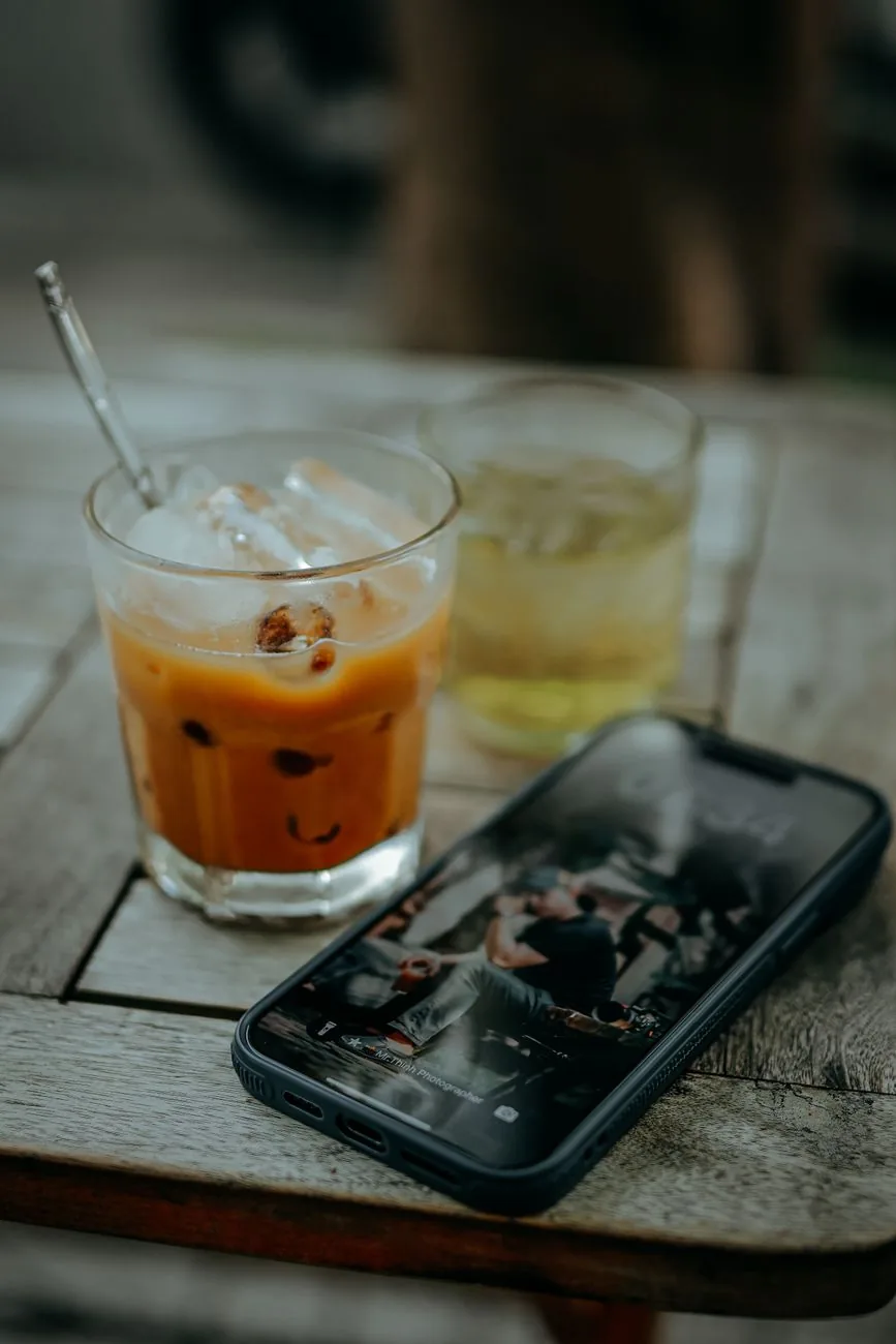 mrożona kawa i smartfon na drewnianym stole na zewnątrz — Honor X9a poza naszym warsztatem — gdzie szukać pomocy