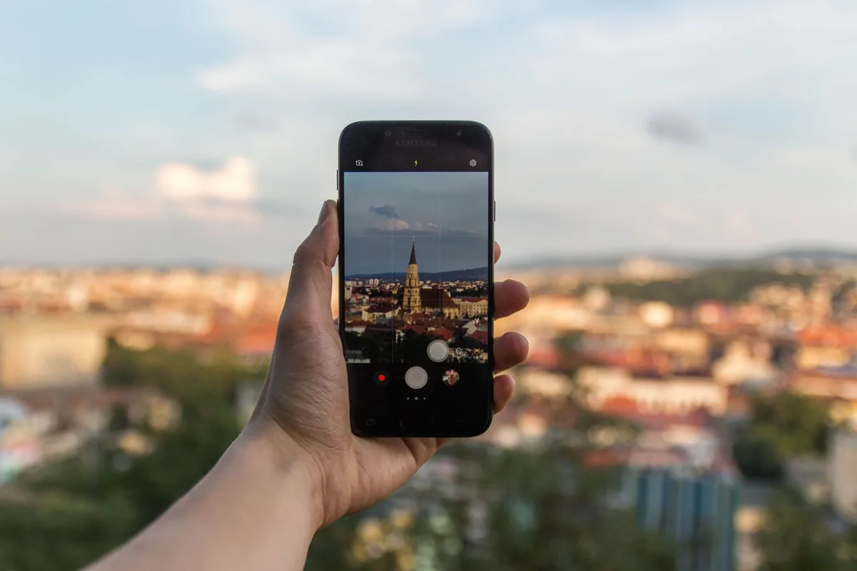 dłoń ze smartfonem na tle panoramy miasta — HTC U12+ w zgłoszeniu — jak odpowiadamy i co radzimy