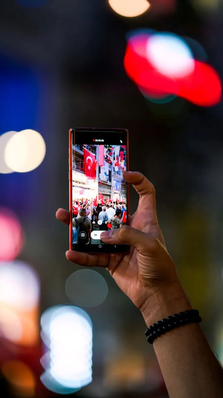 dłoń trzymająca smartfon rejestrujący nocną scenę ze światłami — Huawei Nova 7i poza naszym warsztatem — gdzie szukać pomocy