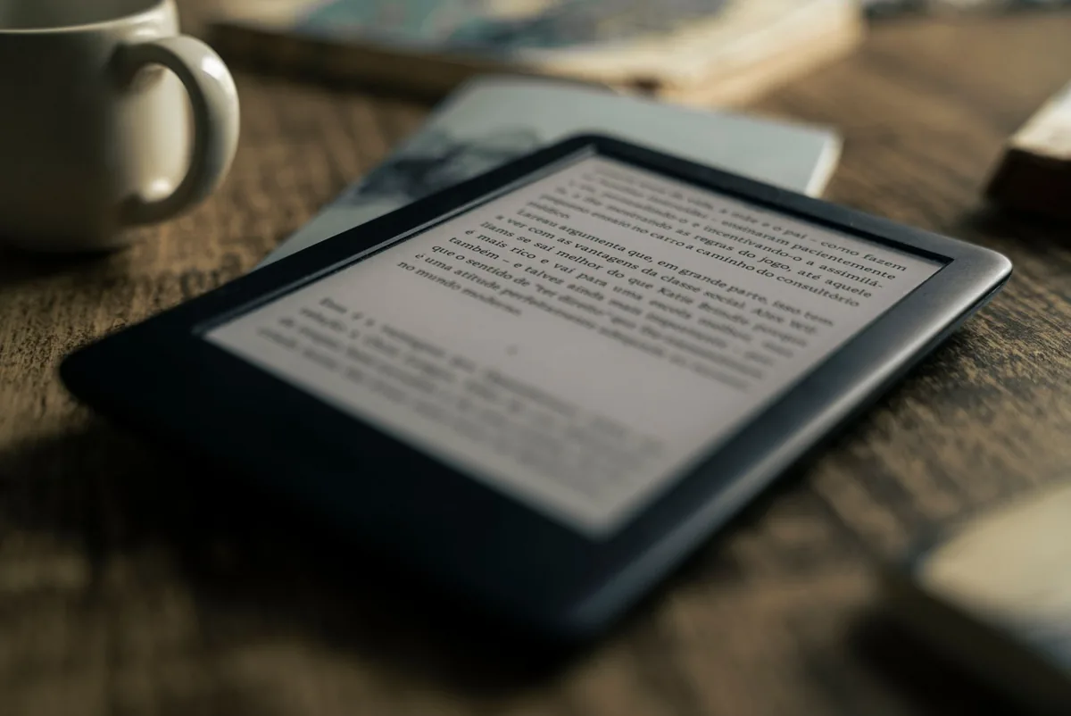 czytnik e-booków obok kubka kawy na drewnianym stole — inkBOOK Focus — czego przy tym sprzęcie nie zrobimy