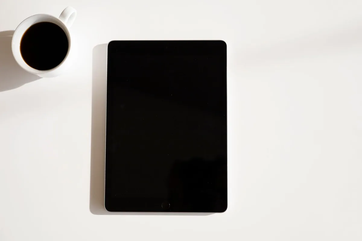 tablet iPad i kubek kawy na białym stole — iPad Air 13 cali M3 — czego przy tym sprzęcie nie zrobimy