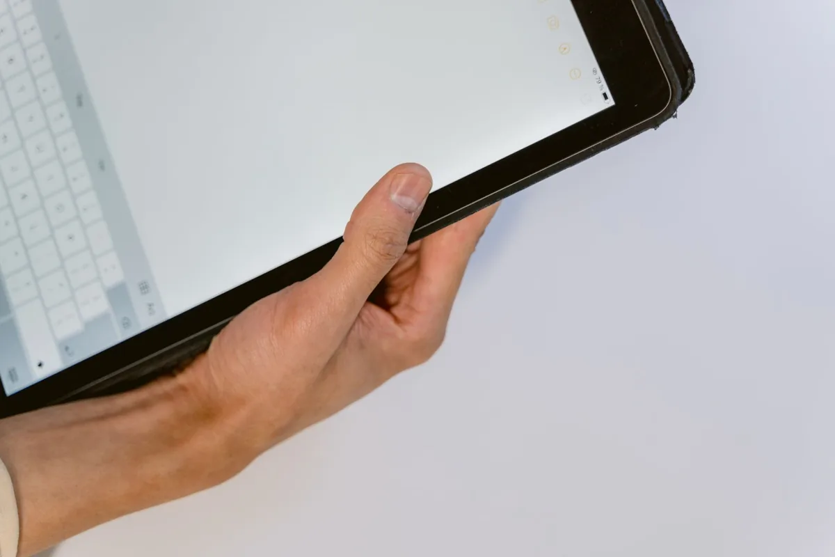 dłoń trzymająca czarny tablet z wirtualną klawiaturą — iPad Air 4 w zgłoszeniu — jak odpowiadamy i co radzimy