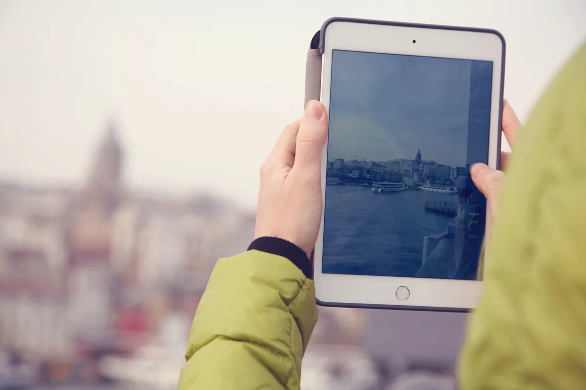 dłonie trzymające tablet na tle panoramy miasta — iPad Pro 9,7 cala poza naszym warsztatem — gdzie szukać pomocy