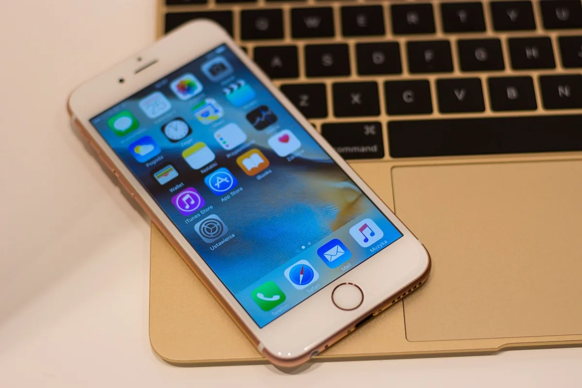 smartfon iphone obok laptopa macbook — iPhone 12 mini w zgłoszeniu — jak odpowiadamy i co radzimy