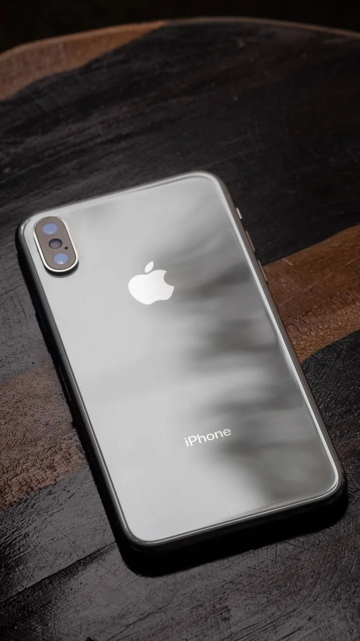 elegancki iPhone na ciemnym drewnianym stole — iPhone 15 Plus — czego przy tym sprzęcie nie zrobimy