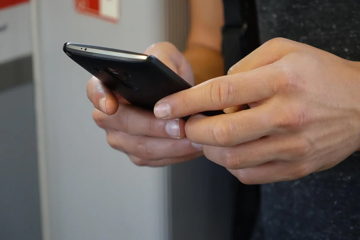 dłonie obsługujące ekran dotykowy telefonu iPhone — iPhone 17 Pro Max a zakres naszego serwisu — czym zajmujemy się zamiast