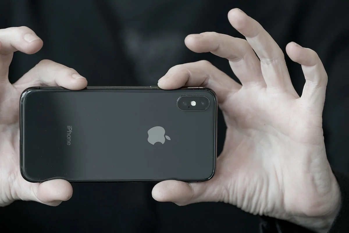 dłonie trzymające smartfon apple iphone x — iPhone SE (2022) 64 GB poza naszym warsztatem — gdzie szukać pomocy