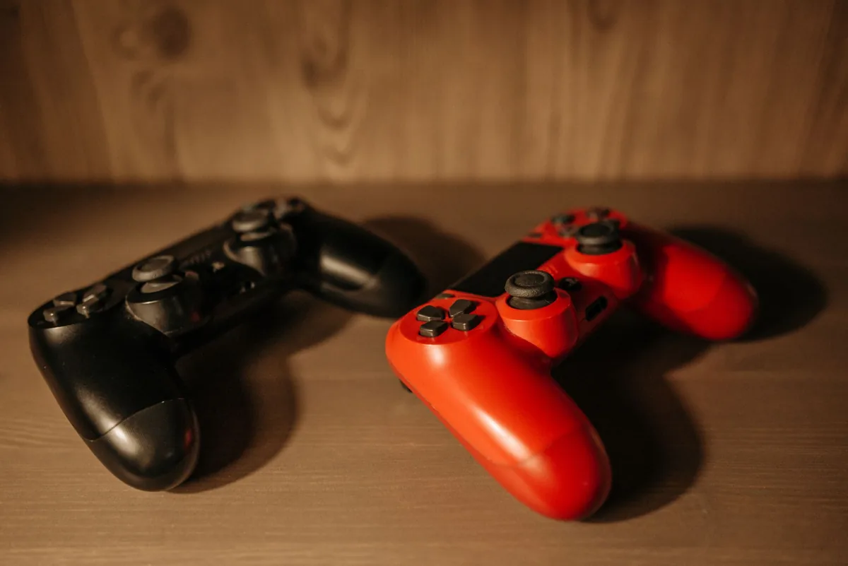 czerwony i czarny kontroler na drewnianej powierzchni — Joy-Con 2 — czego przy tym sprzęcie nie zrobimy