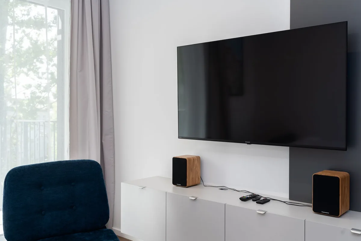 drewniane kolumny głośnikowe obok telewizora w eleganckim salonie — KEF Q950 w zgłoszeniu — jak odpowiadamy i co radzimy