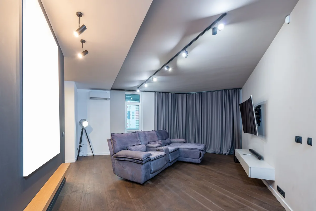 telewizor na ścianie i szara sofa w eleganckim salonie — LG OLED CX — czego przy tym sprzęcie nie zrobimy