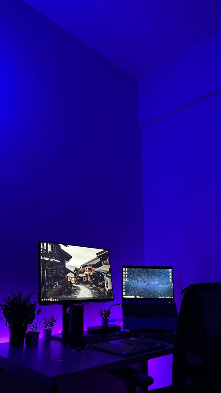 dwa ekrany na biurku gamingowym w niebieskim oświetleniu — LG UltraGear 27GR95QE poza naszym warsztatem — gdzie szukać pomocy