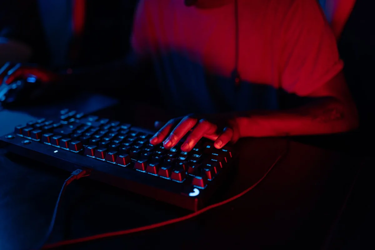 dłonie piszące na klawiaturze gamingowej z podświetleniem rgb — Logitech K360 a zakres naszego serwisu — czym zajmujemy się zamiast