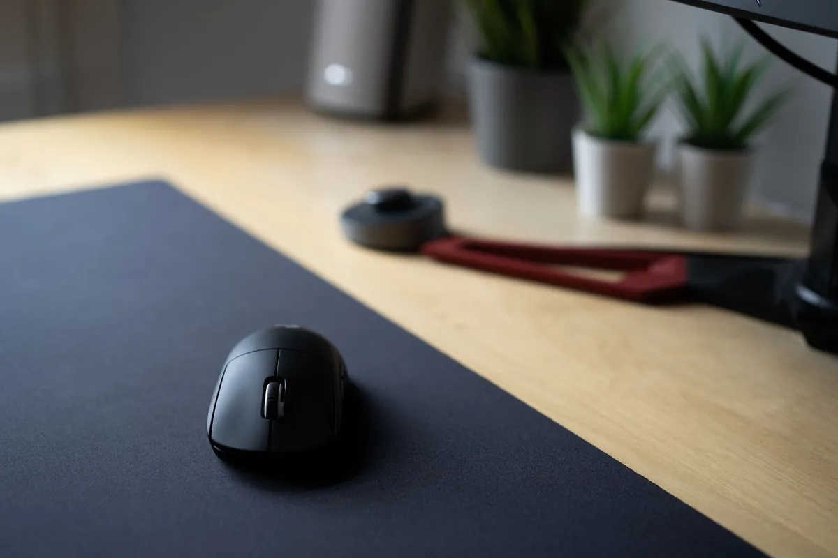bezprzewodowa mysz na czarnej podkładce na biurku z roślinami — Logitech Lift poza naszym warsztatem — gdzie szukać pomocy