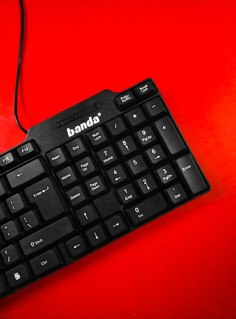 czarna klawiatura komputerowa na jaskrawoczerwonym tle — Logitech MX Keys a zakres naszego serwisu — czym zajmujemy się zamiast