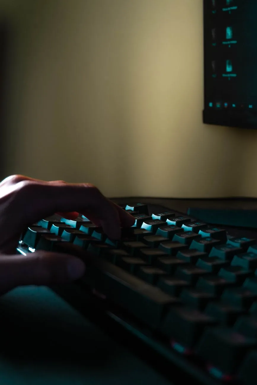 dłoń na klawiaturze przed świecącym ekranem — Logitech MX Mechanical — czego przy tym sprzęcie nie zrobimy