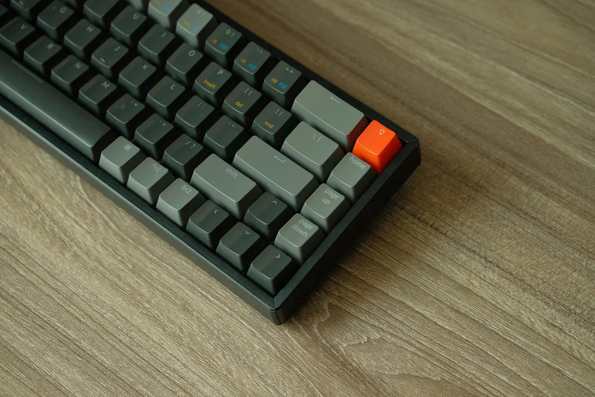 klawiatura mechaniczna z pomarańczowym klawiszem na drewnianym stole — Logitech Pop Keys w zgłoszeniu — jak odpowiadamy i co radzimy