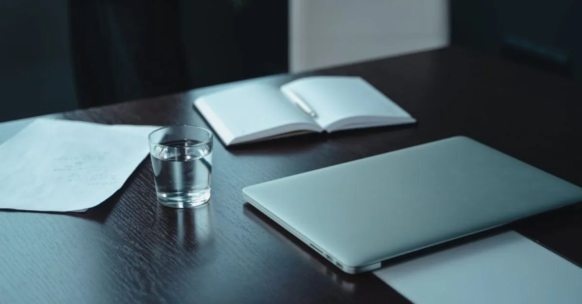 Zamknięty srebrny laptop przypominający MacBooka na biurku z notatnikiem — MacBook Air 13 cali (2014) w zgłoszeniu — jak odpowiadamy i co radzimy