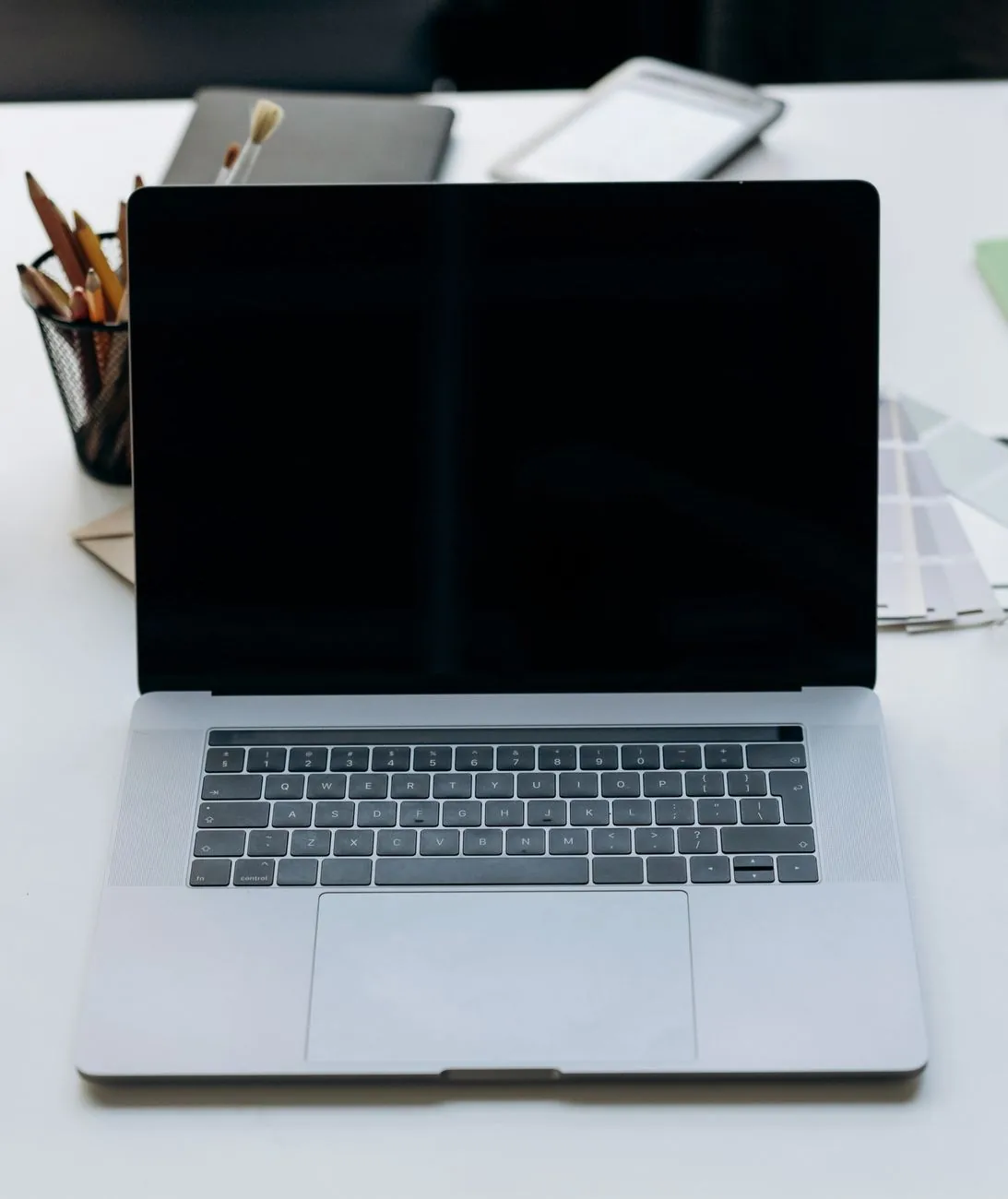 laptop z czarnym ekranem na minimalistycznym biurku z akcesoriami — MacBook Air 13 cali (2017) 8 GB — czego przy tym sprzęcie nie zrobimy