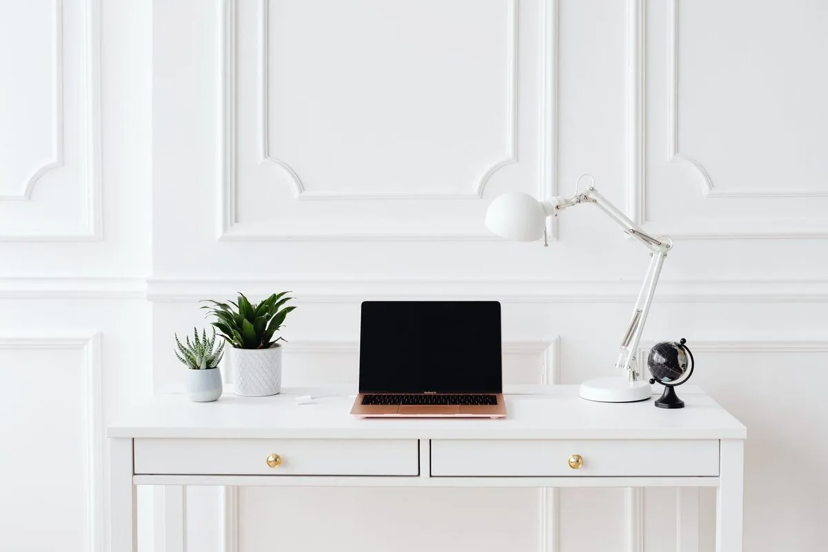 Różowo-złoty MacBook na białym biurku z roślinami i lampką — MacBook Air M3 15 cali (2024) w zgłoszeniu — jak odpowiadamy i co radzimy