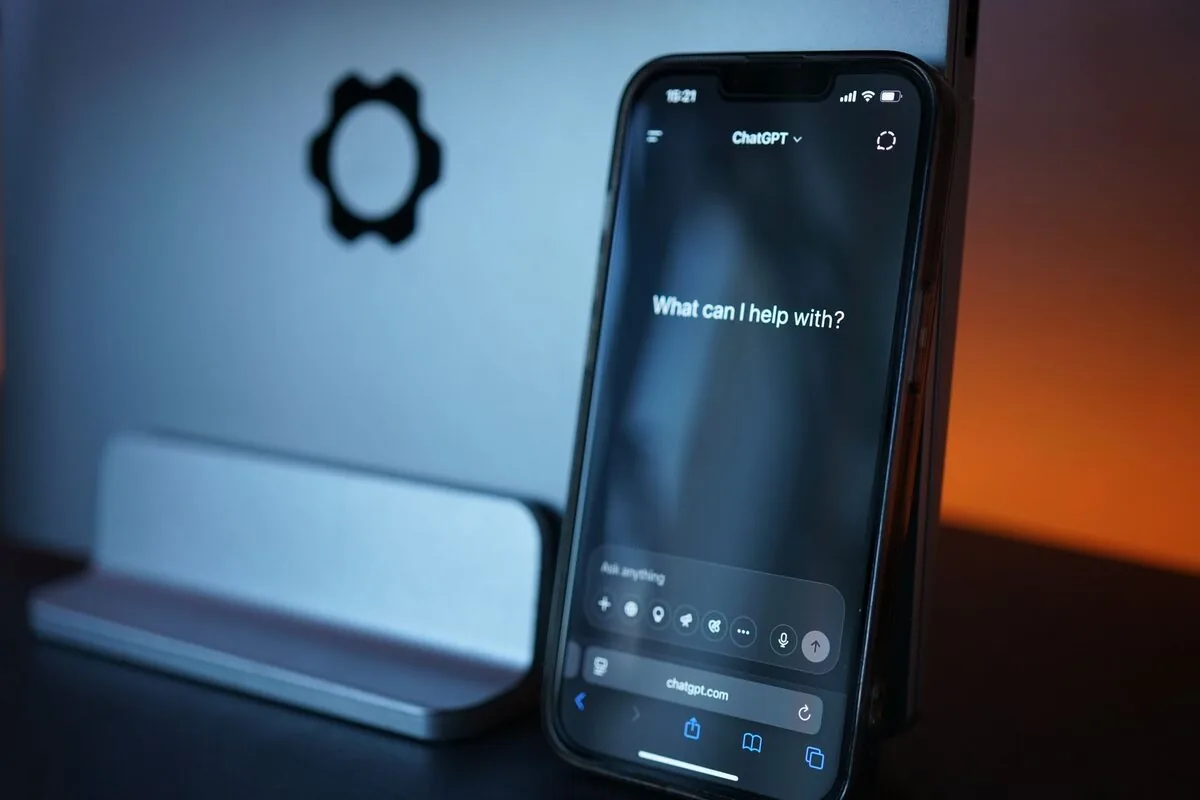 iPhone z aplikacją ChatGPT oparty o laptop Apple na biurku — MacBook Air M4 13 cali (2025) poza naszym warsztatem — gdzie szukać pomocy