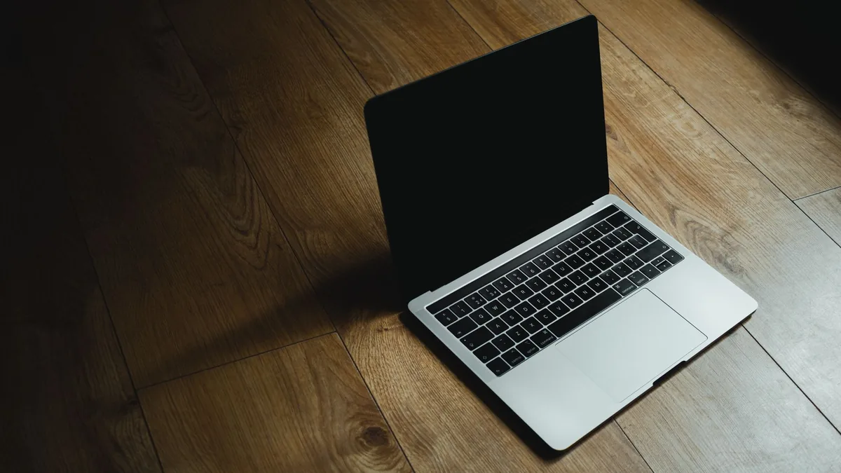 laptop MacBook położony na ciepłej drewnianej podłodze — MacBook Pro 13 cali (2014) a zakres naszego serwisu — czym zajmujemy się zamiast