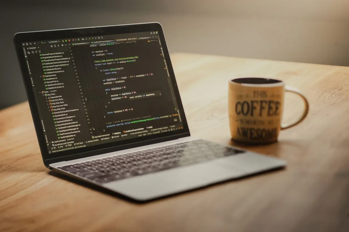 MacBook 12 cali z kodem na ekranie, kubek kawy — MacBook Pro 13 cali (2020) w zgłoszeniu — jak odpowiadamy i co radzimy