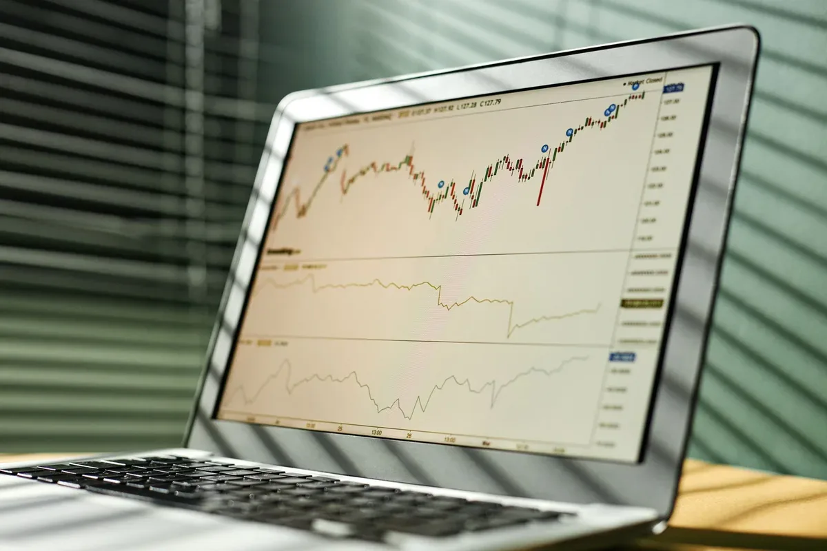 srebrny MacBook Air z wykresem giełdowym na ekranie — MacBook Pro 13 cali M1 (2020) poza naszym warsztatem — gdzie szukać pomocy